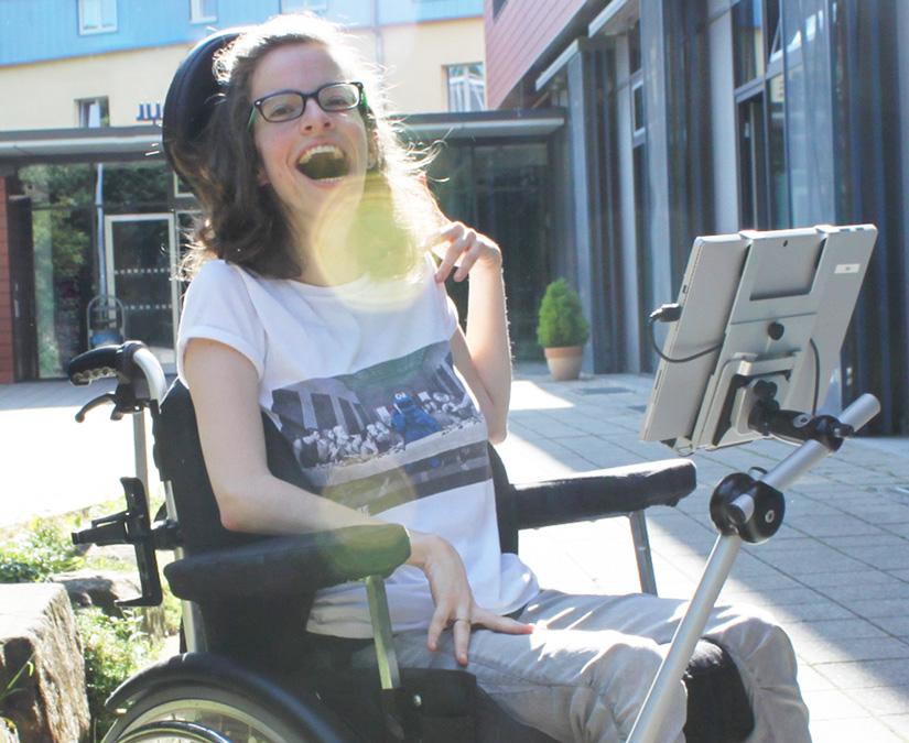 Ung kvinna som använder sin Tobii Dynavox PCEye-hållare utomhus