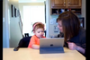 Image of little kid using tablet with woman